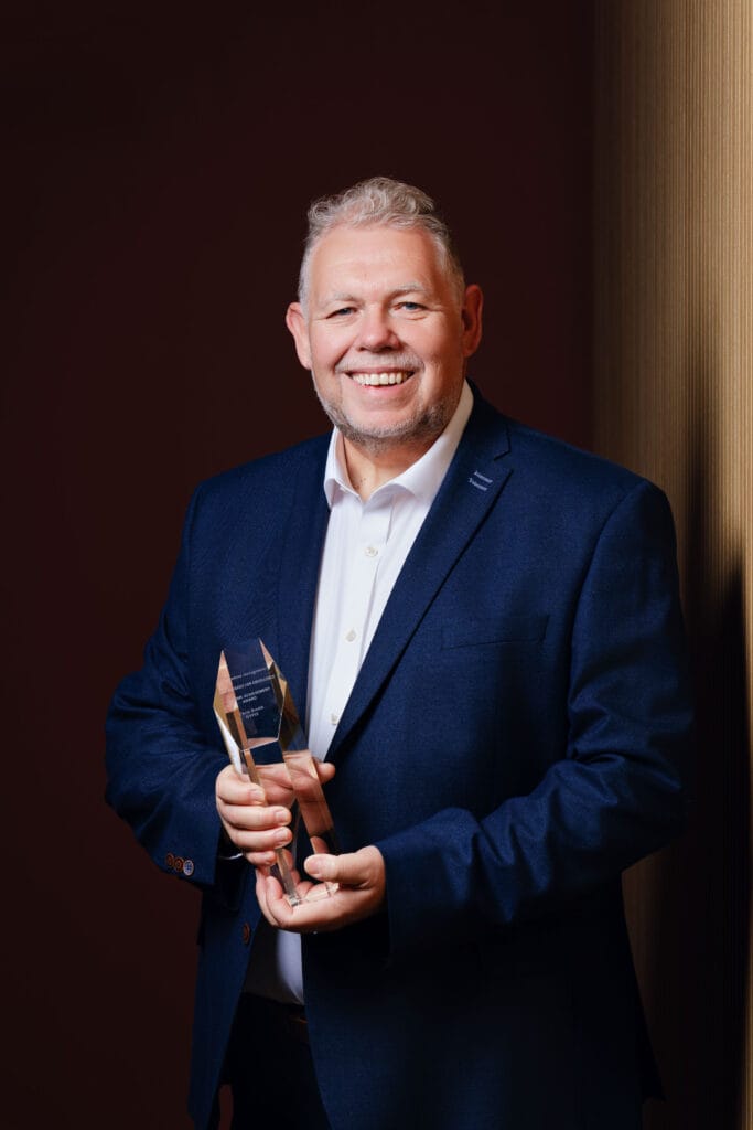 Chris Smith holding his Lifetime Achievement Award, symbolising a career of innovation.